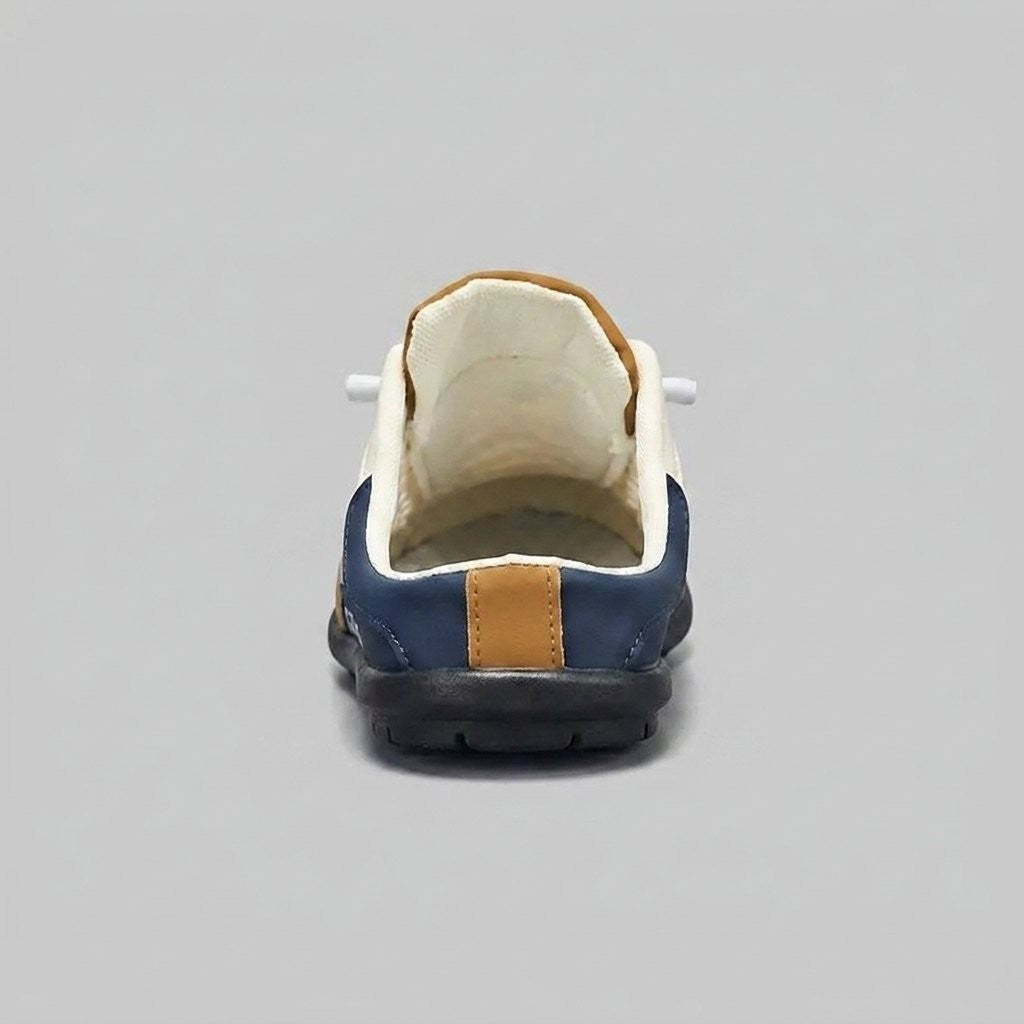 Rear view of navy backless trainer mule with tan heel tab