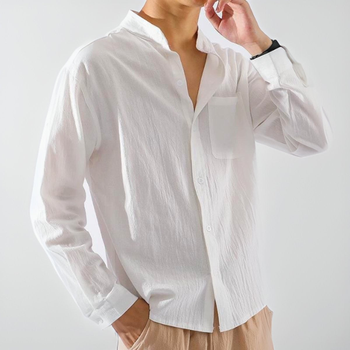 Man modelling white relaxed-fit button-up shirt with stand collar and cuffed sleeves