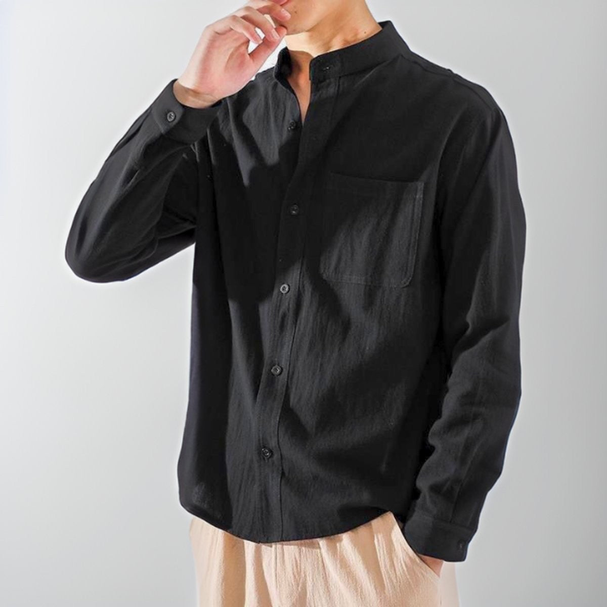 Black cotton band-collar shirt with chest pocket, worn in relaxed fit