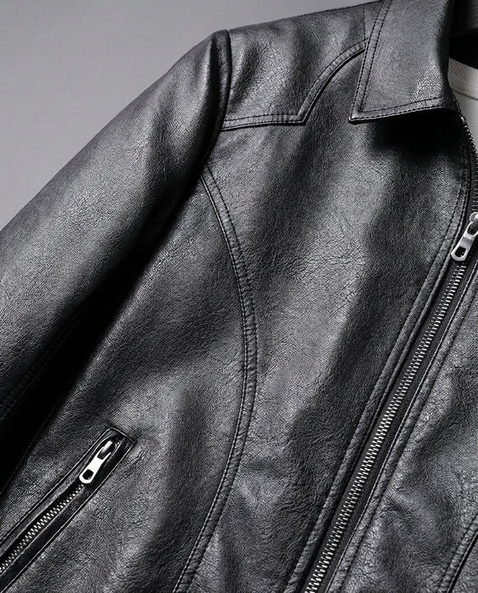 Close-up of black leather jacket shoulder seam, collar and zip pocket detail