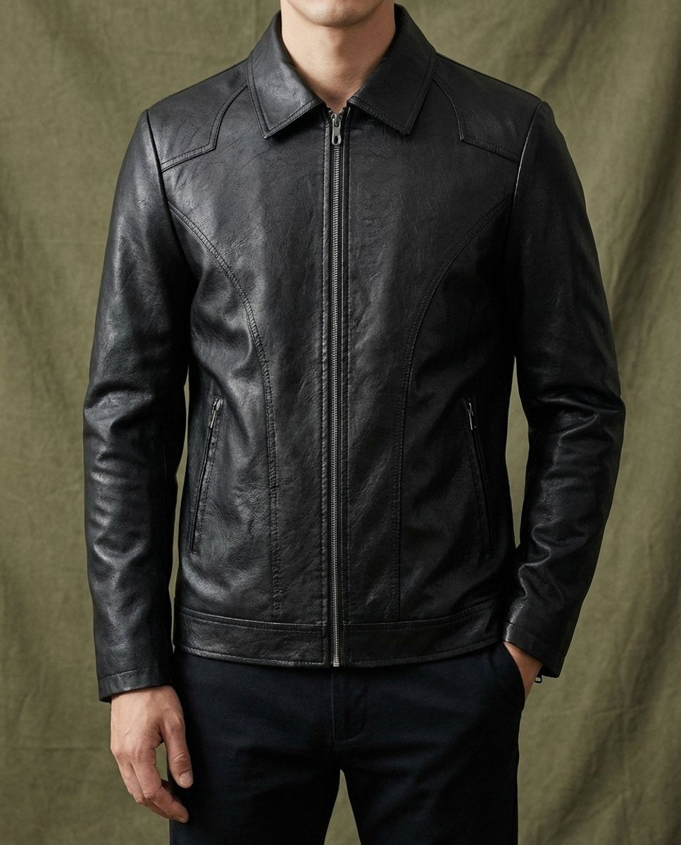 Model wearing black leather zip-up jacket over navy trousers, front detail shot