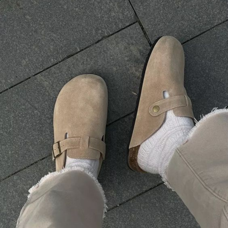Sandy beige suede clogs paired with frayed cream trousers