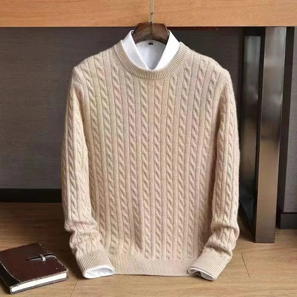Cream cable knit crew neck jumper layered over white collared shirt
