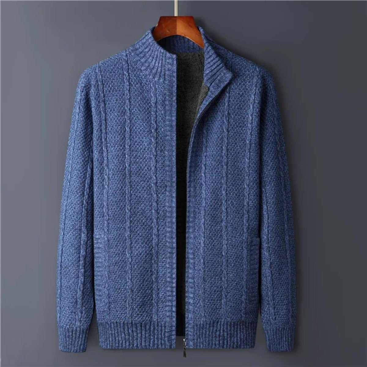 Blue cable-knit full-zip cardigan with stand collar on wooden hanger
