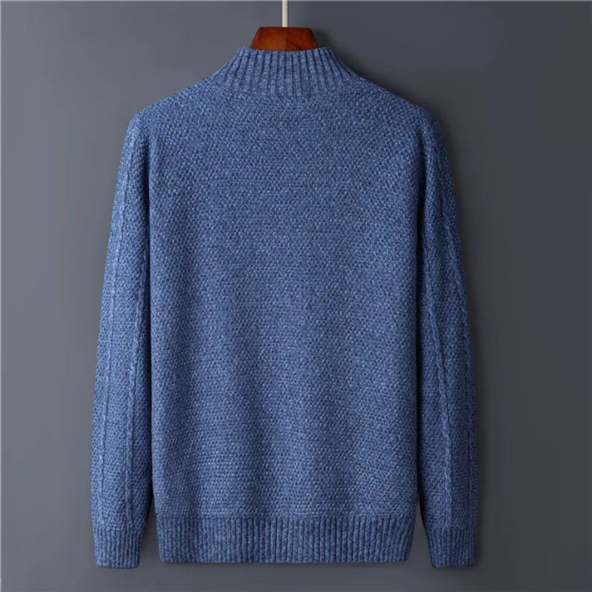 Back view of blue cable-knit wool cardigan showing ribbed collar