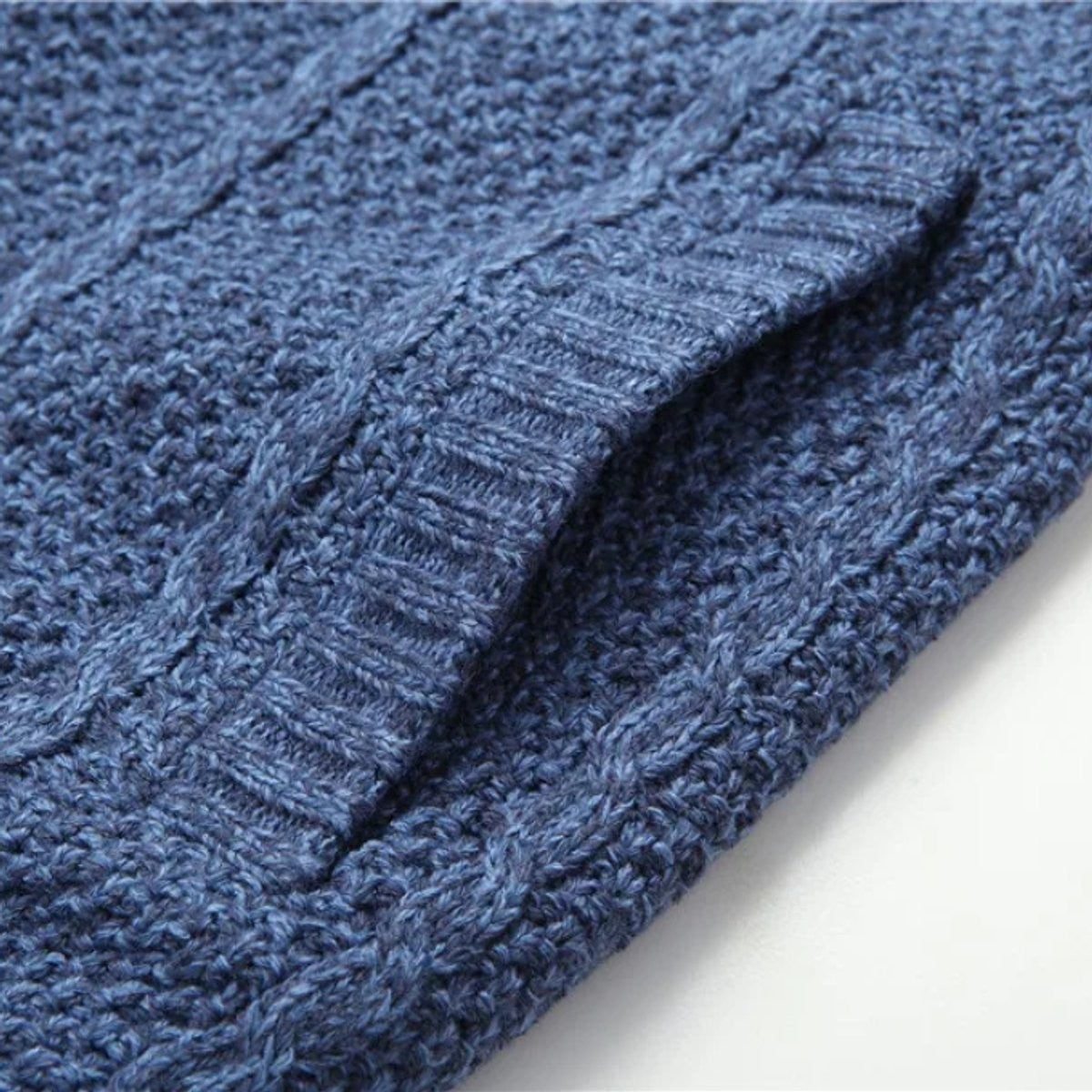 Detail of ribbed cuff and pocket on blue knitted cardigan