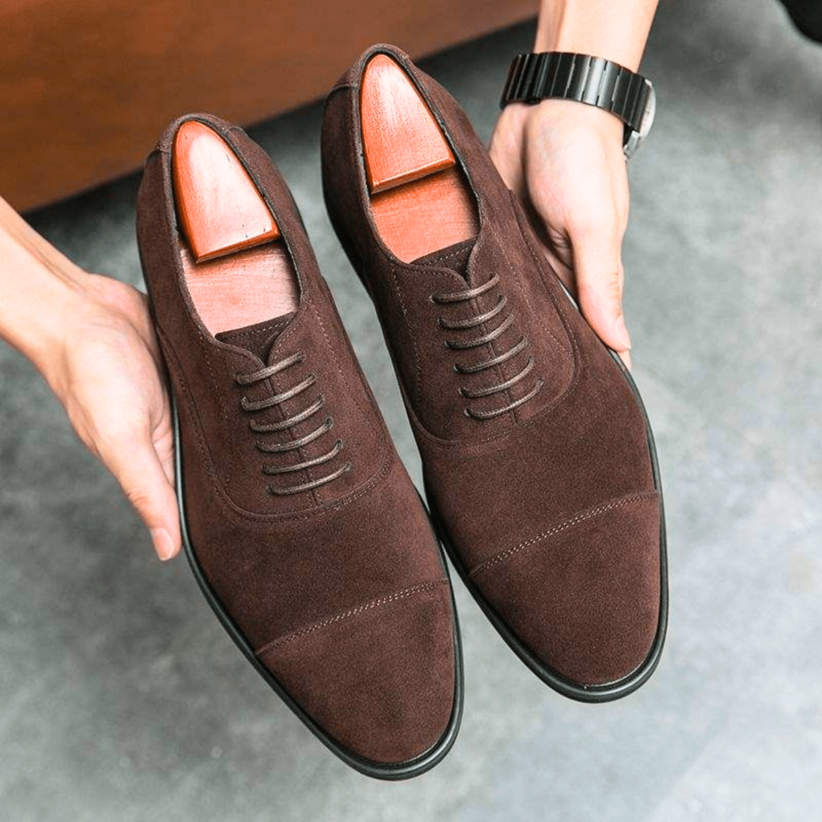 Pair of brown suede cap-toe Oxford shoes with lace-up detailing