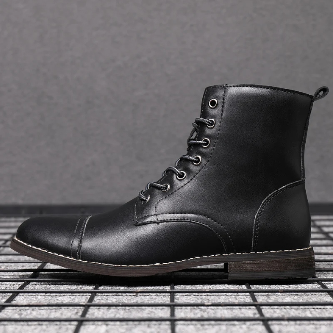 Men's black leather ankle boots styled on grid-patterned flooring