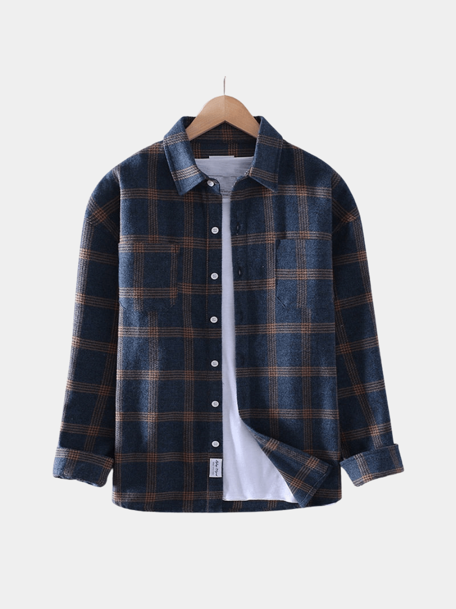 Navy and rust checked flannel shirt with chest pockets on a hanger