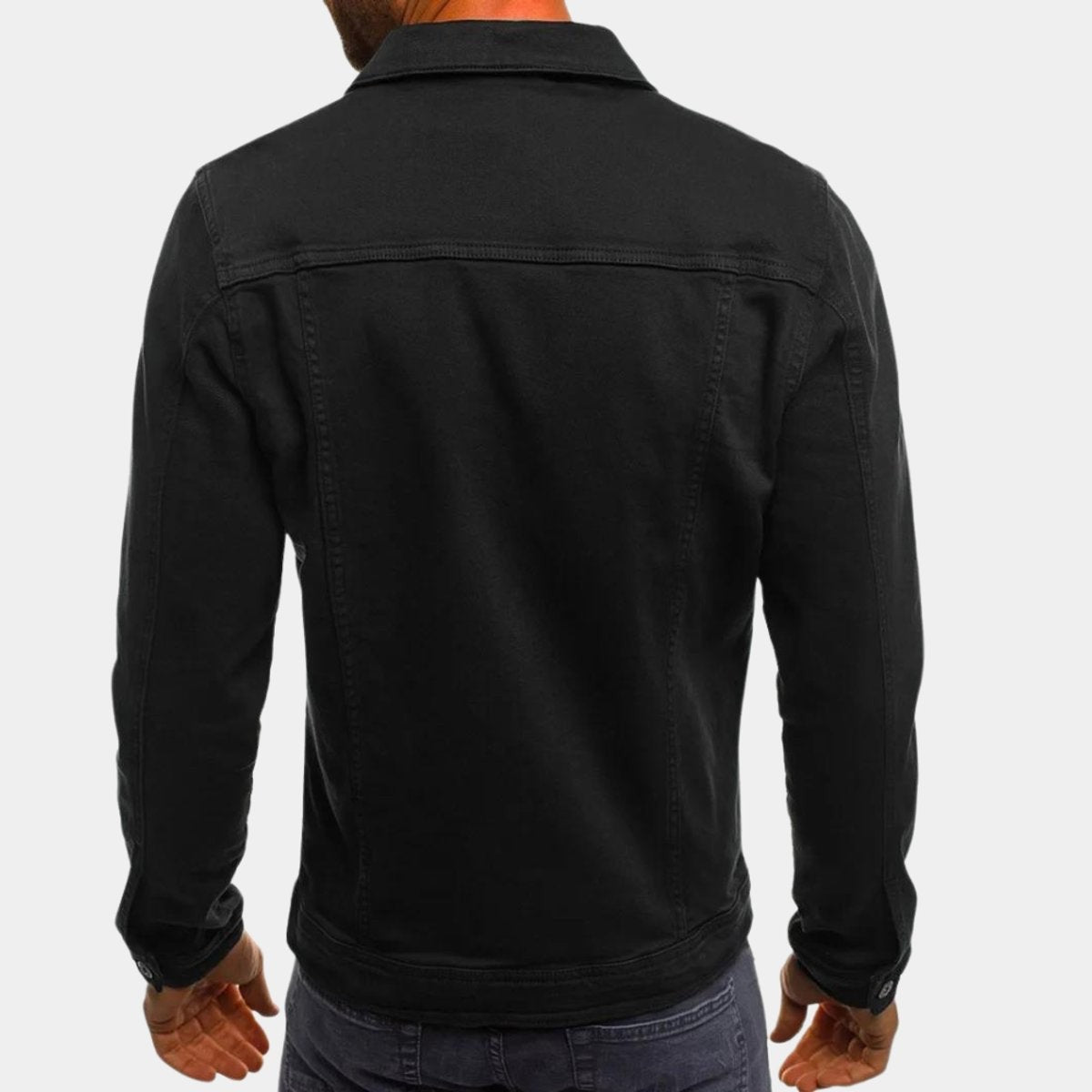 Rear view of black denim jacket showing seam detailing and collar
