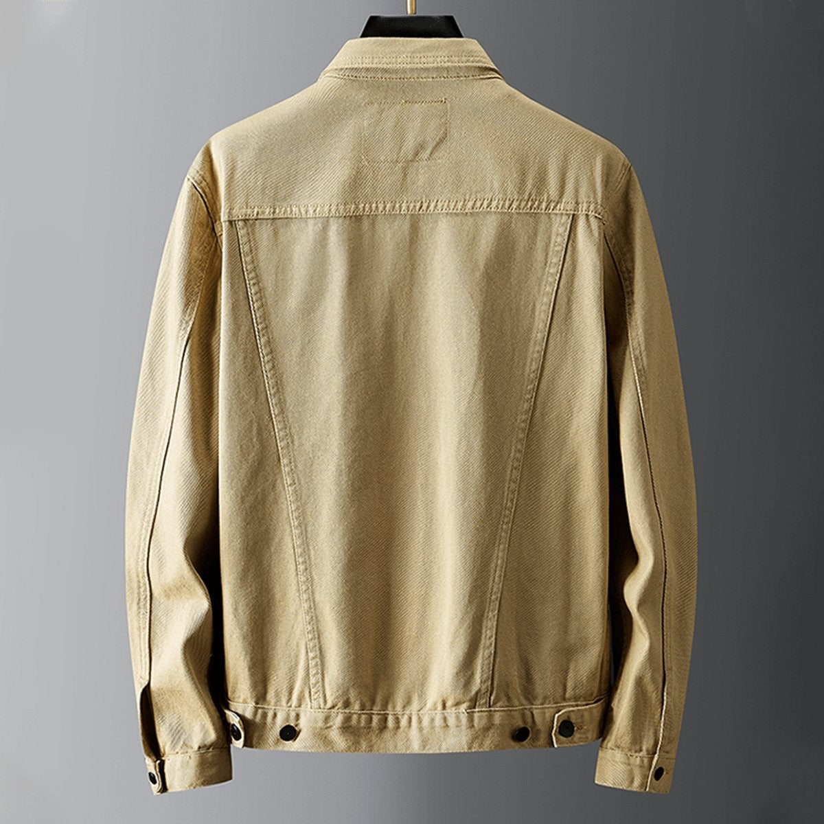 Rear view of khaki denim jacket showing seam detailing and cuffed sleeves
