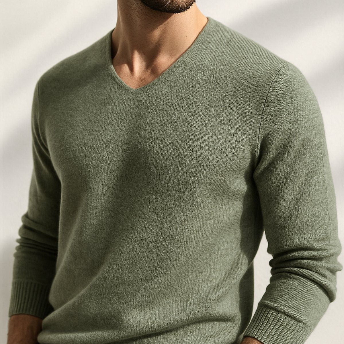 Man wearing a sage green cashmere blend V-neck knitted jumper