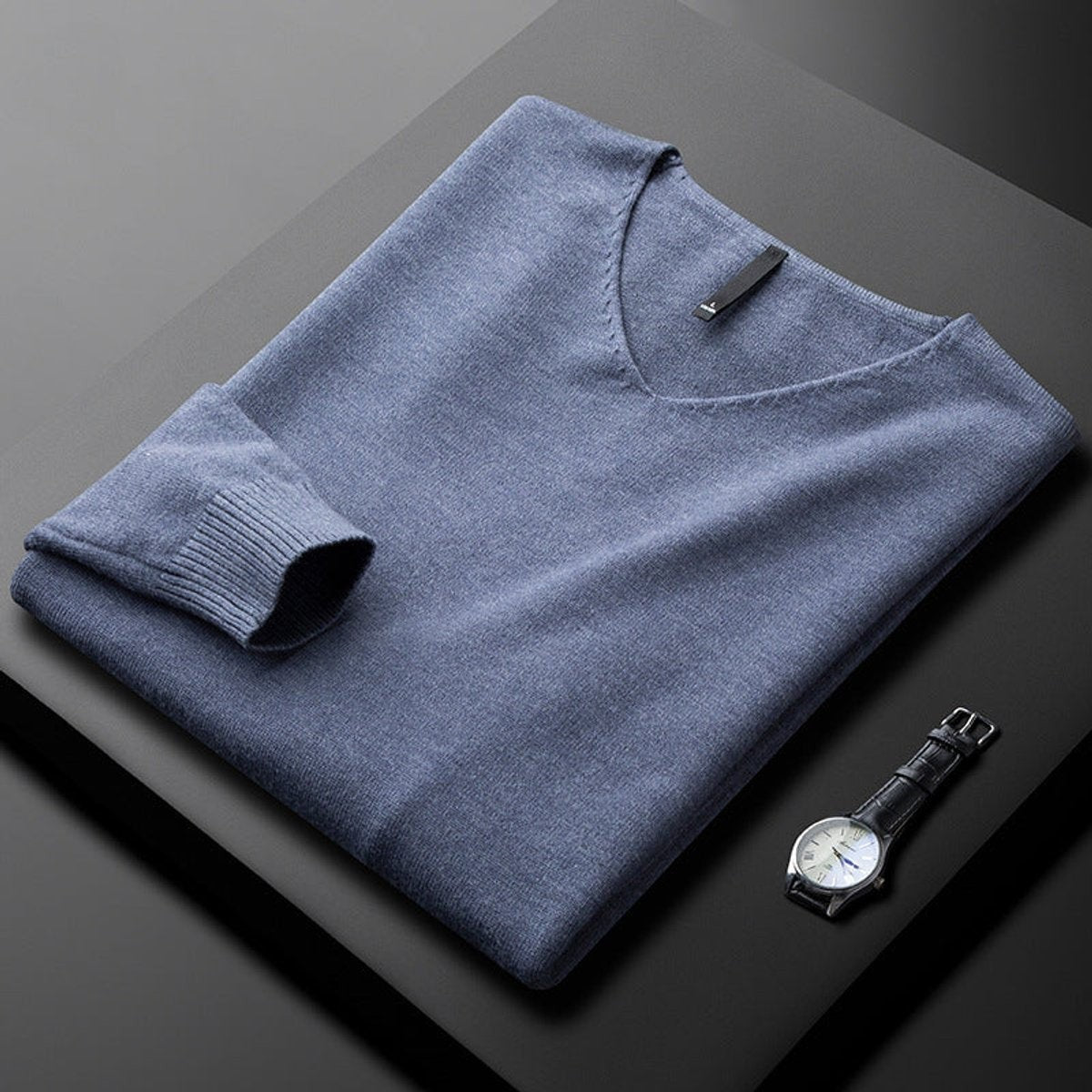 Folded slate blue V-neck knitted jumper with ribbed cuffs and hem