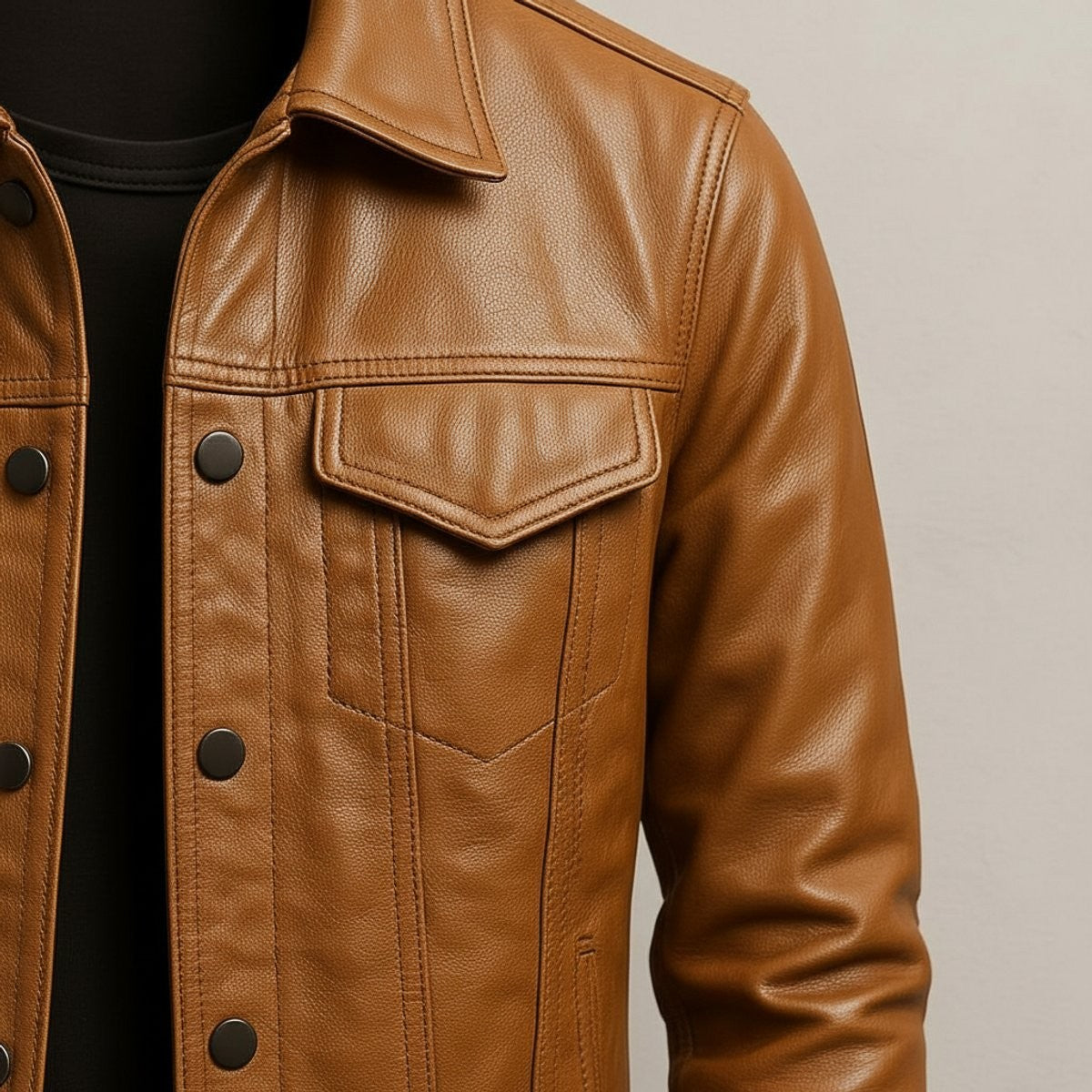 Close-up of tan leather jacket chest pocket with press-stud fastening