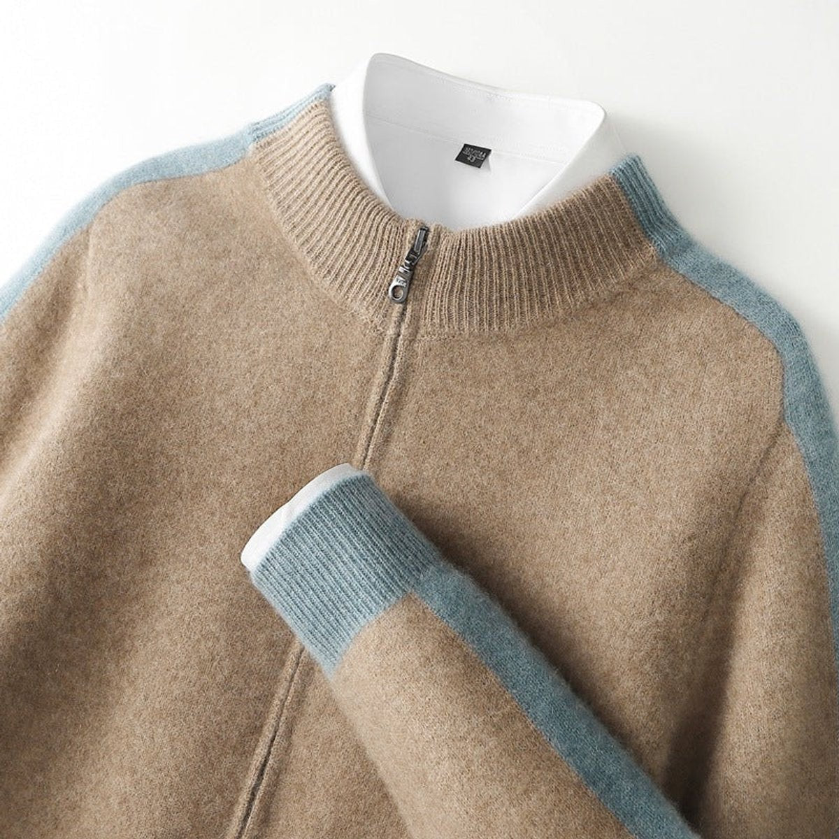 Close-up of camel cashmere cardigan collar showing blue contrast zip trim
