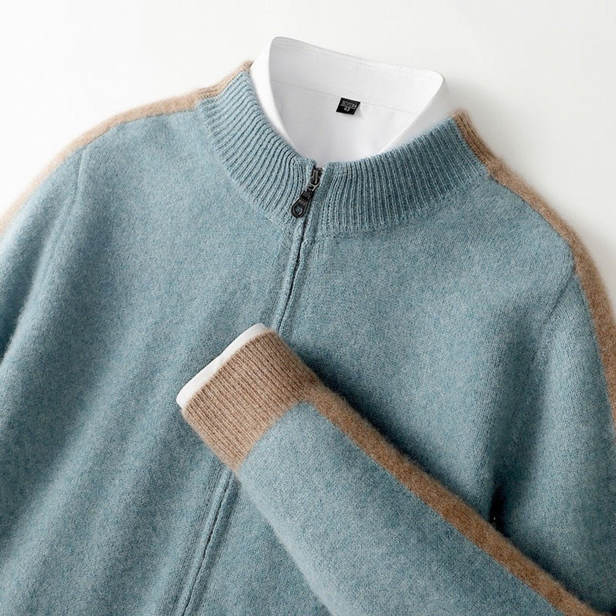 Close-up of pale blue cashmere cardigan collar with camel contrast detailing