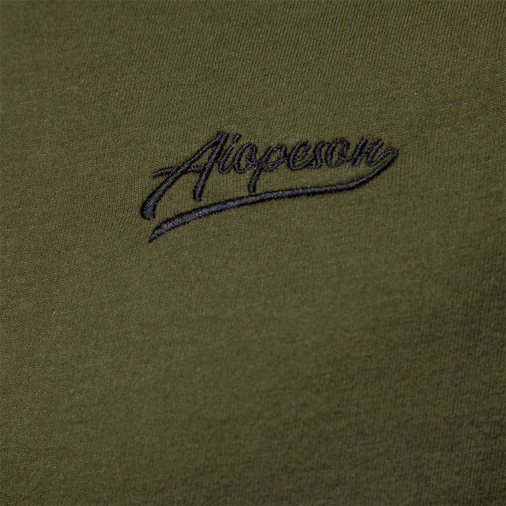 Close-up of embroidered logo on khaki green long sleeve shirt