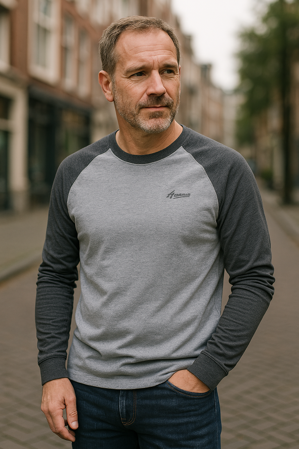 Man wearing grey raglan long sleeve top with dark contrast sleeves outdoors