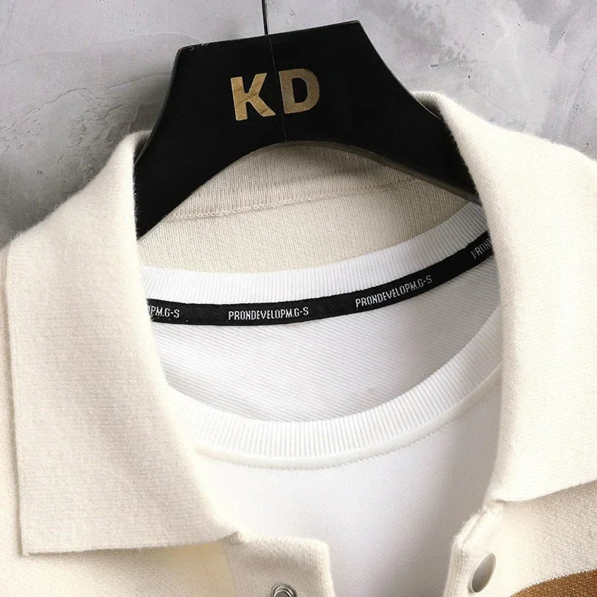 Close-up of cream cardigan collar and jersey T-shirt neckline label detail