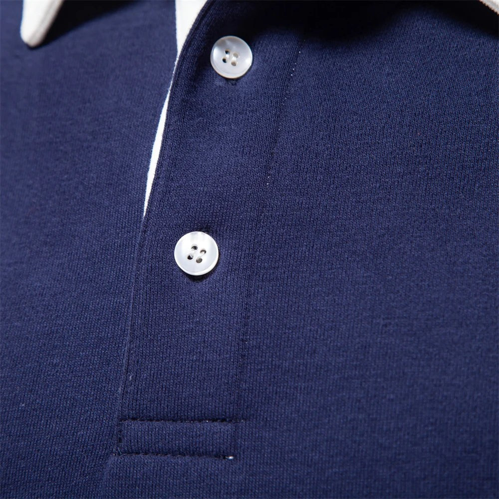 Close-up of navy polo placket showing mother-of-pearl style buttons