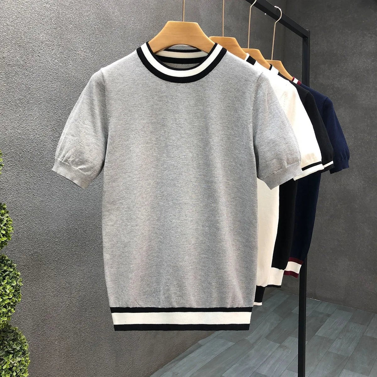 Grey short-sleeve knitted jumper featuring black and white striped collar detail