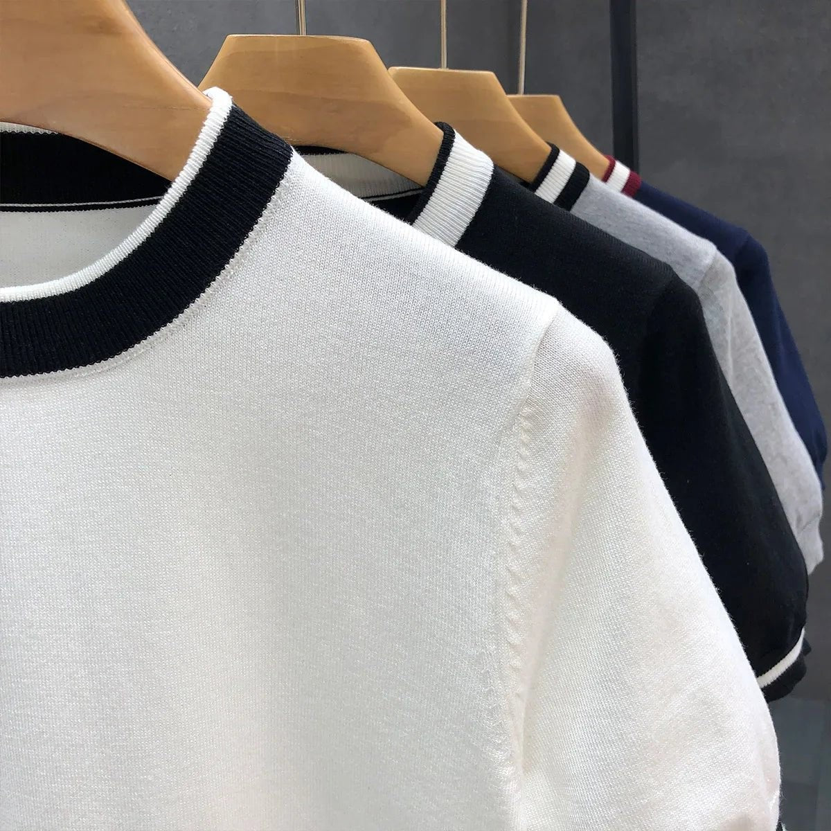 Close-up of striped crewneck trims on lightweight knitted jumpers in various colours