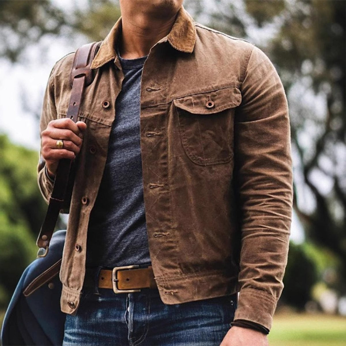 Close-up of tan waxed cotton jacket styled with denim jeans and leather belt
