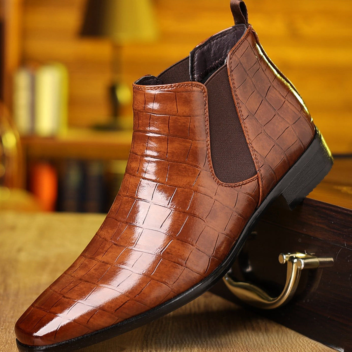 Close-up of tan crocodile-textured leather Chelsea boot with elasticated gusset