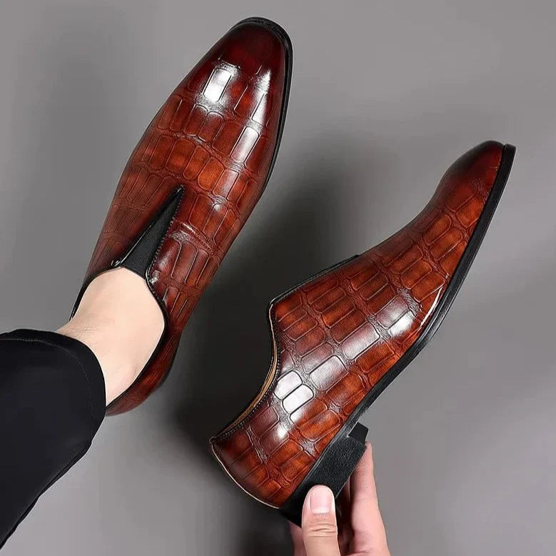 Pair of burgundy croc-effect leather slip-on shoes shown from above
