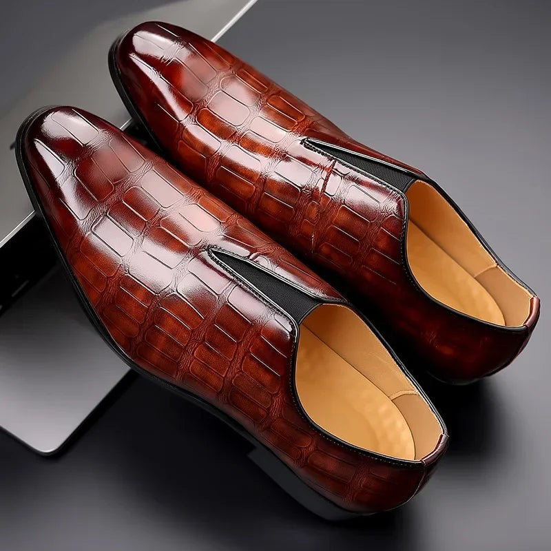 Close-up of burgundy croc-textured leather dress shoes on model's feet