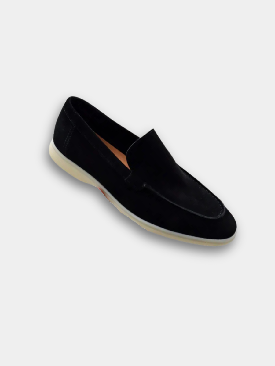 Black suede loafer with white sole shown at an angle