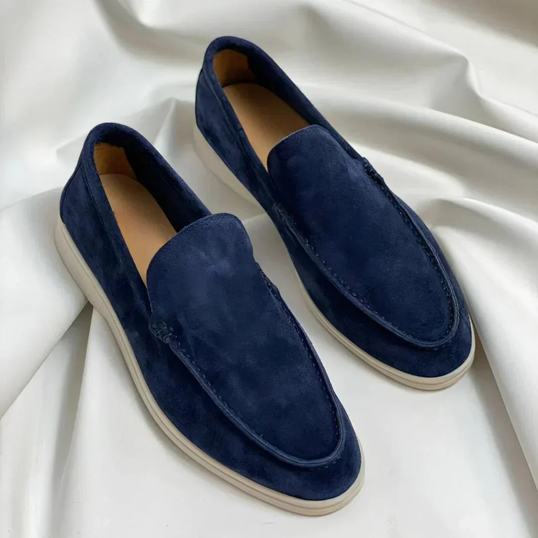 Navy suede loafers with white soles on draped fabric