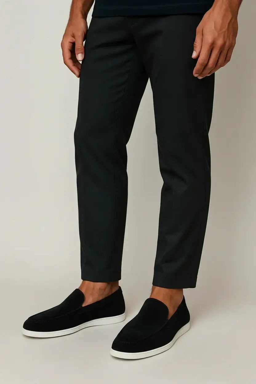 Model wearing black suede loafers with cropped black trousers
