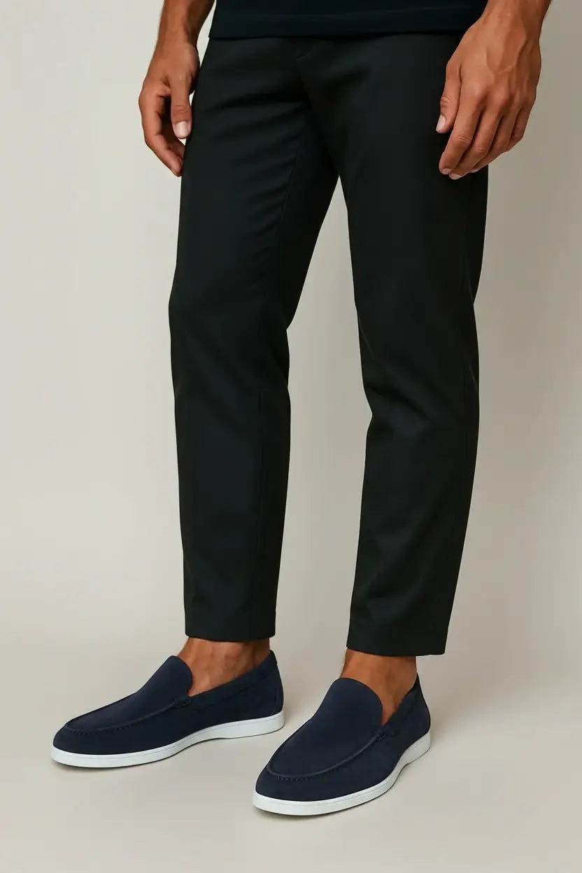 Model wearing navy suede loafers paired with tapered black trousers