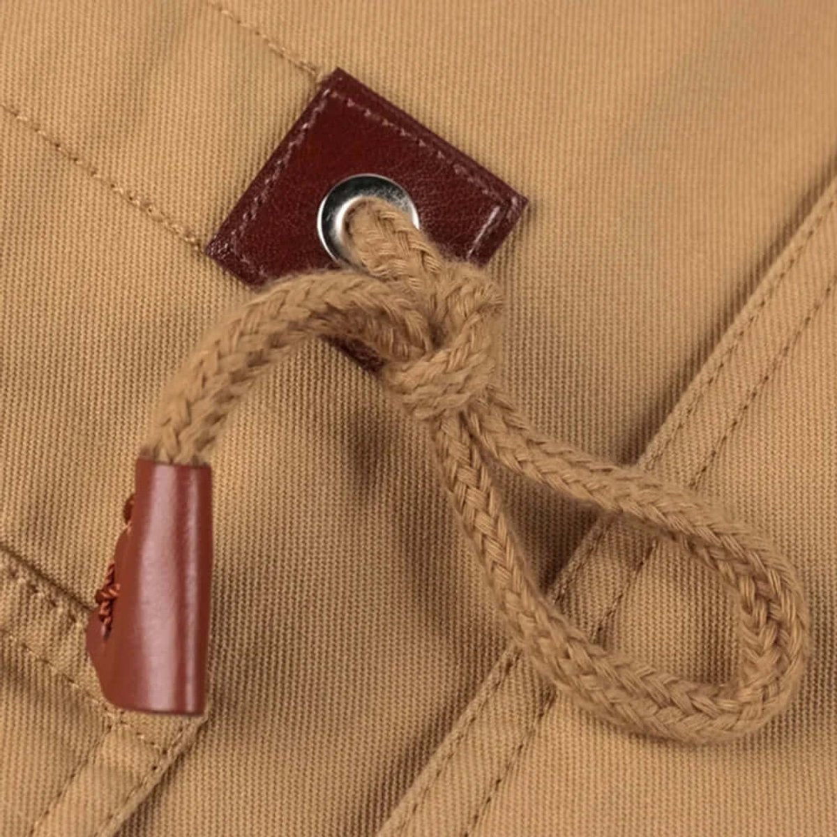 Detail shot of leather drawstring toggle and eyelet on cargo jacket pocket