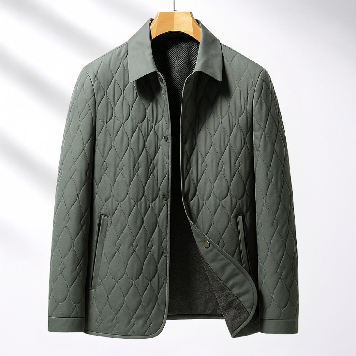 Sage green quilted button-front jacket displayed on wooden hanger