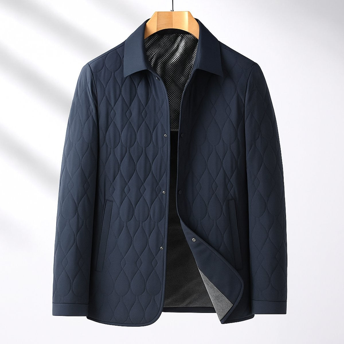 Navy quilted button-front bomber jacket shown on wooden hanger