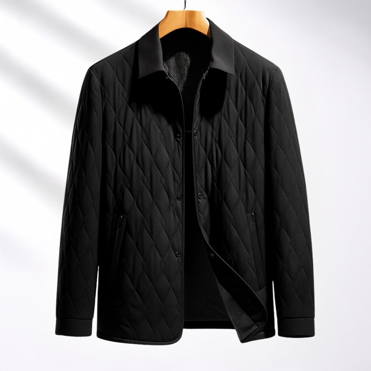 Black quilted button-front bomber jacket displayed on wooden hanger