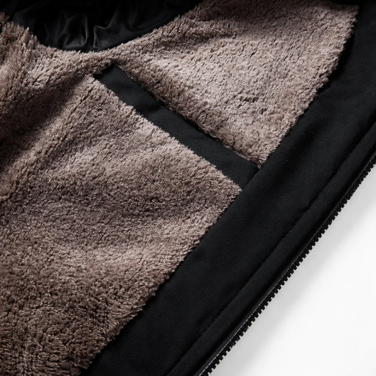 Close-up of brown fleece lining and stitched pocket detail inside black bomber