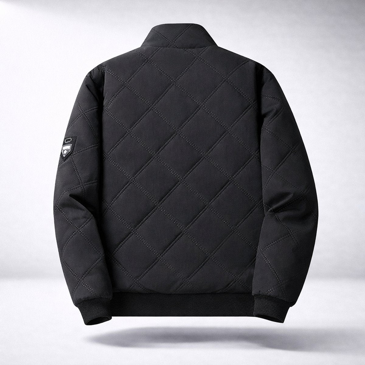 Rear view of black quilted bomber jacket with ribbed cuffs and hem