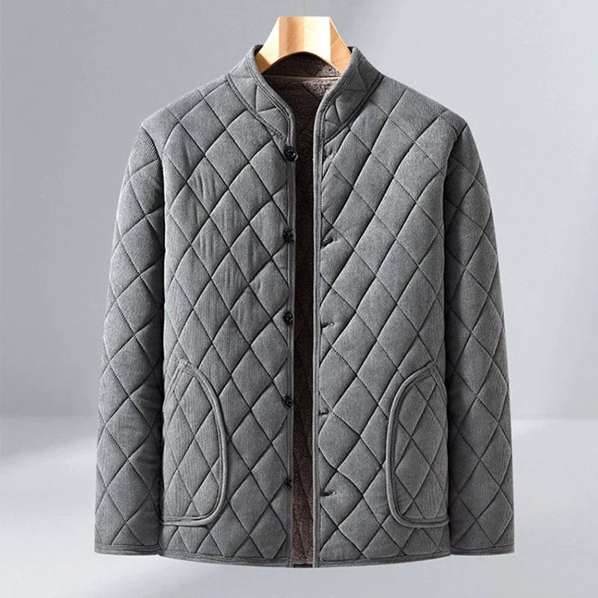 Grey diamond-quilted jacket with stand collar and fleece-lined interior on hanger