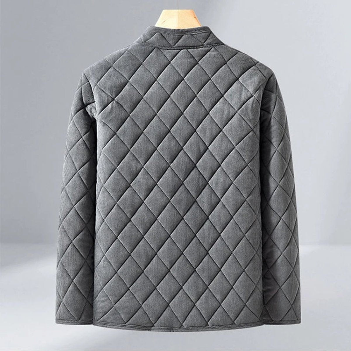 Rear view of grey diamond-quilted jacket highlighting corduroy-textured stitching