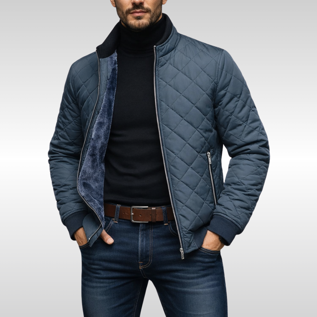 Steel blue quilted jacket unzipped over black jumper and jeans