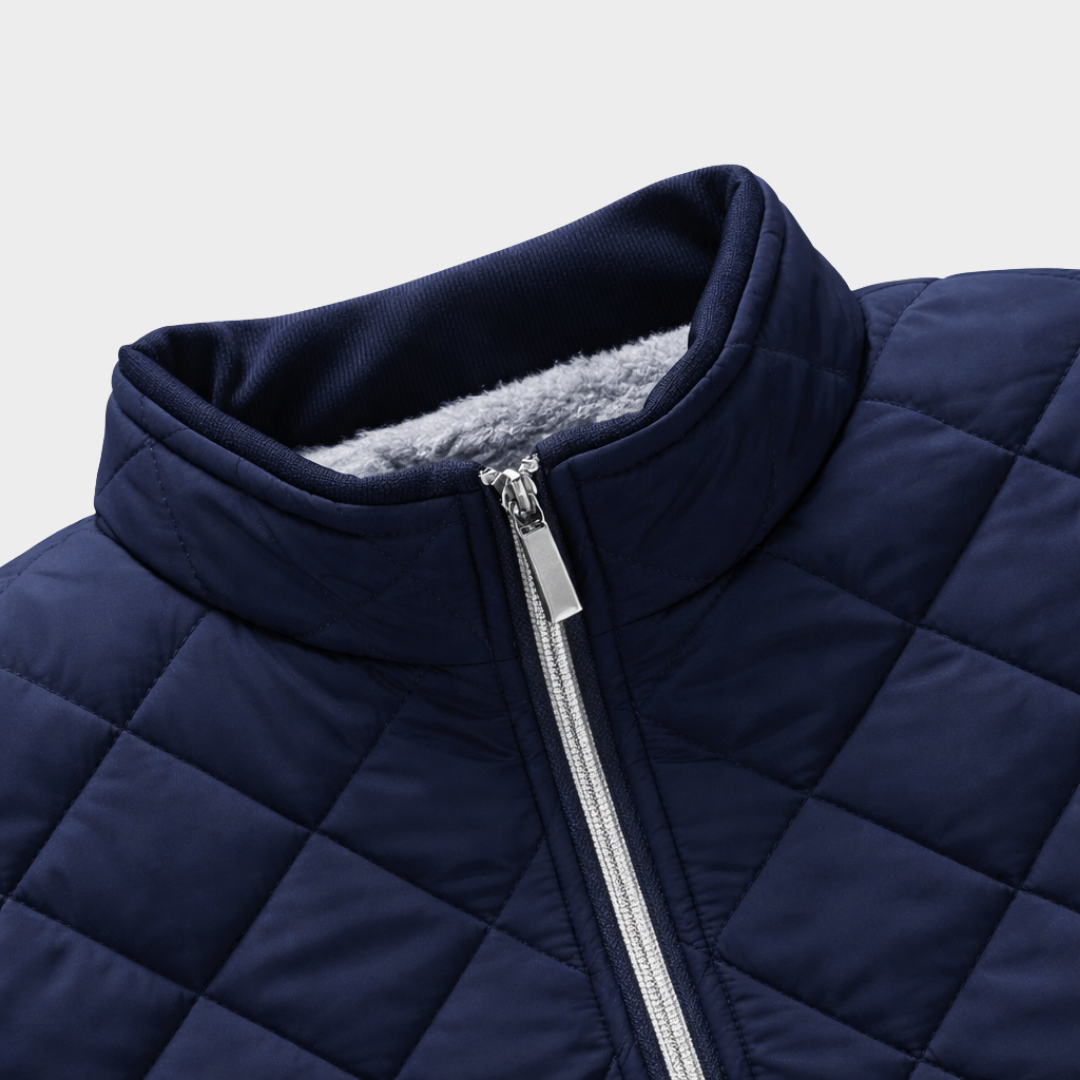 Close-up of navy quilted jacket collar with silver zip fastening