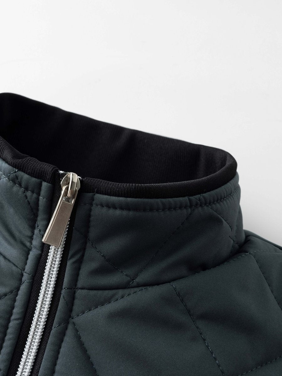 Close-up of dark teal quilted jacket collar with silver zip detail