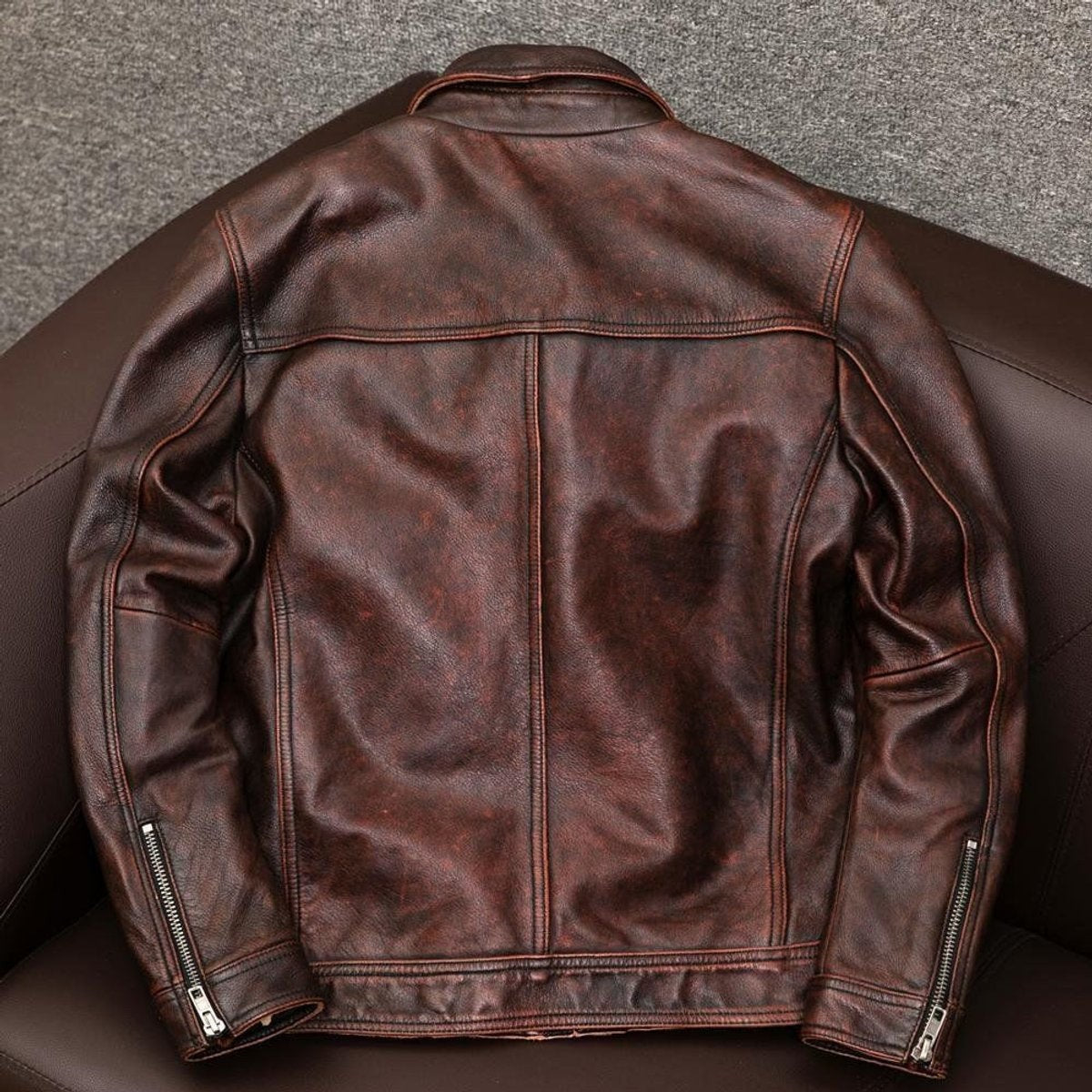Back view of distressed brown leather jacket showing seam detailing