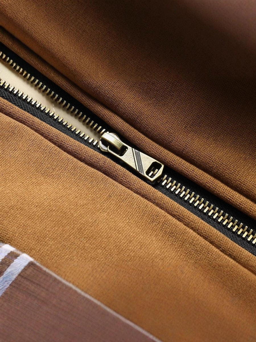 Close-up of quilted jacket lining showing brass zip and tan fabric