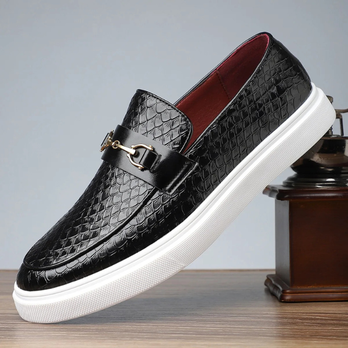 Black snakeskin-effect leather loafers featuring gold buckle trim and white sole