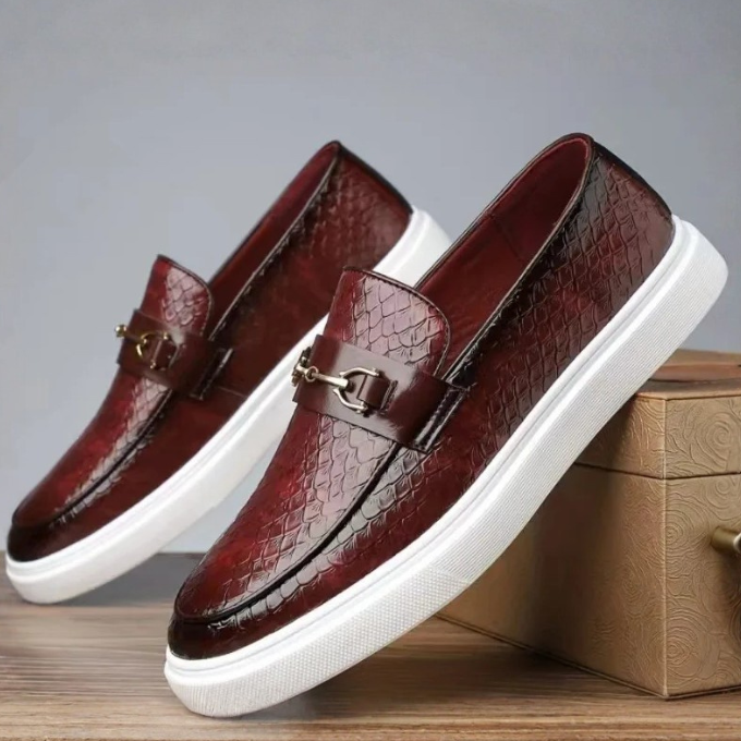 Burgundy leather loafers with snakeskin texture, gold buckle and white sole