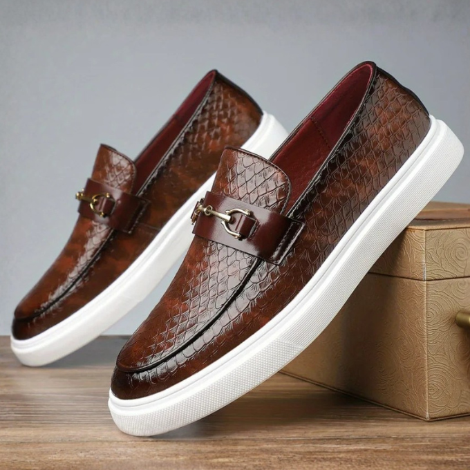 Brown embossed leather loafers featuring white sole and metal bit detail